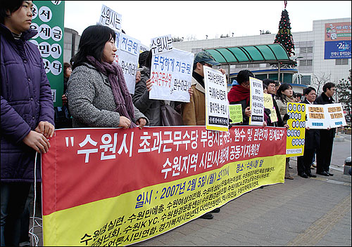 수원지역 시민단체 관계자와 회원들이 수원시를 규탄하는 각종 구호가 적힌 피켓을 든 채 기자회견을 하고 있다. 